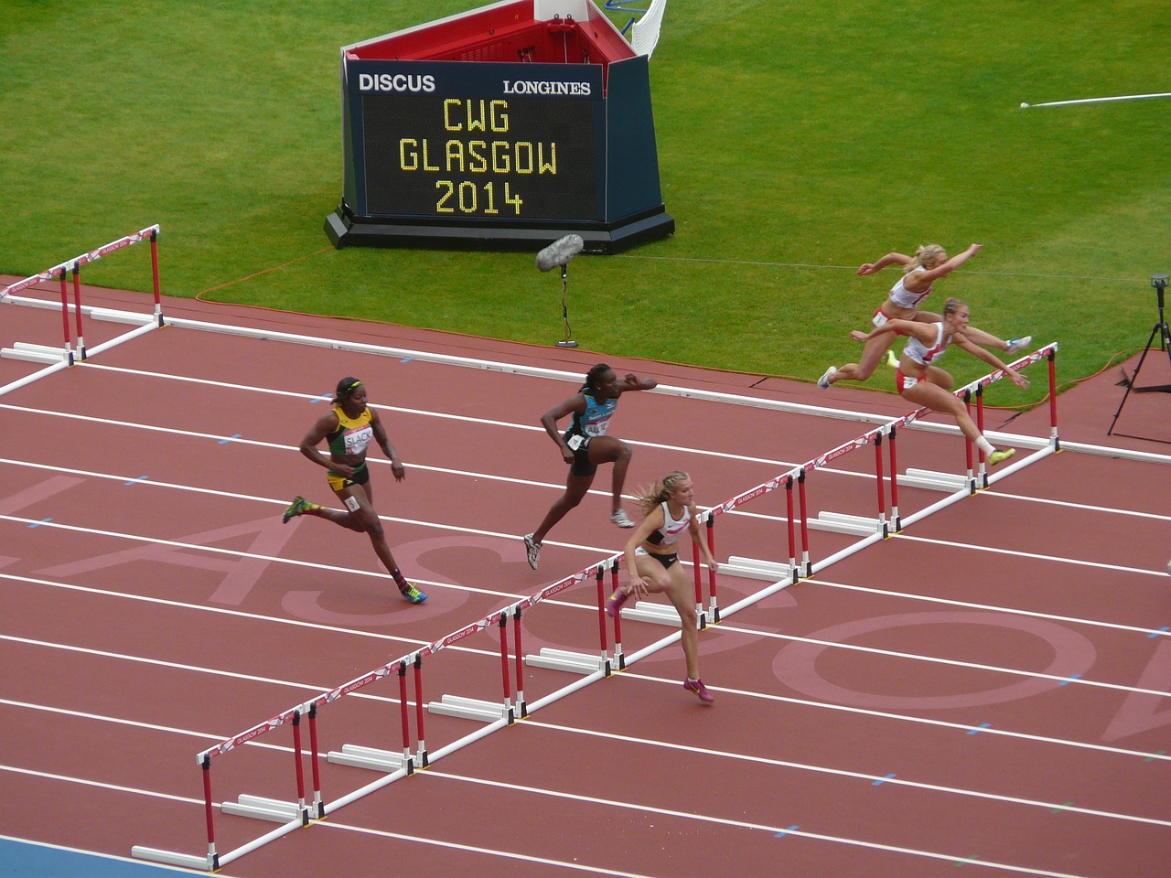 Track runner jumping over hurdles