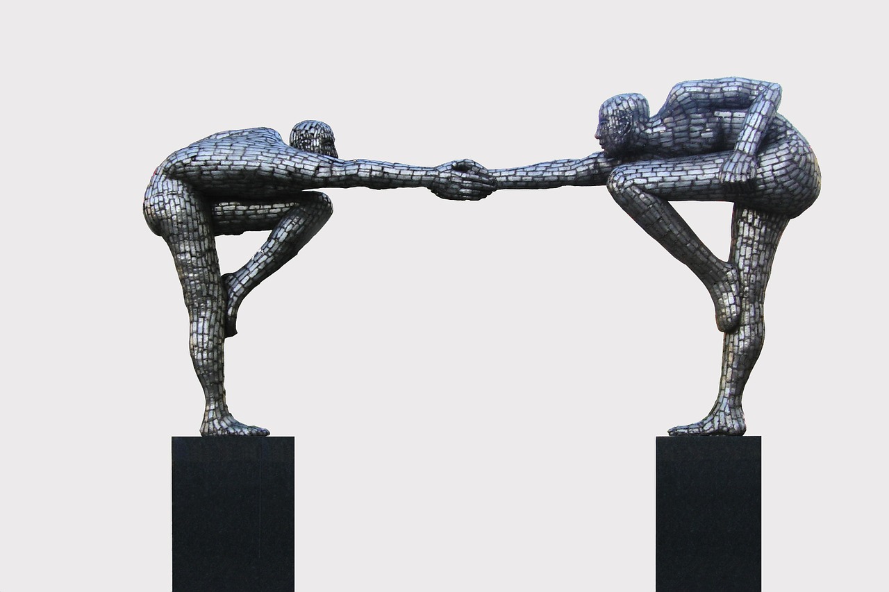 Sculpture of two people reaching for each other