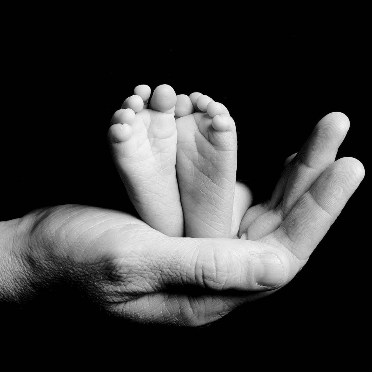 Parent holding baby feet in hand