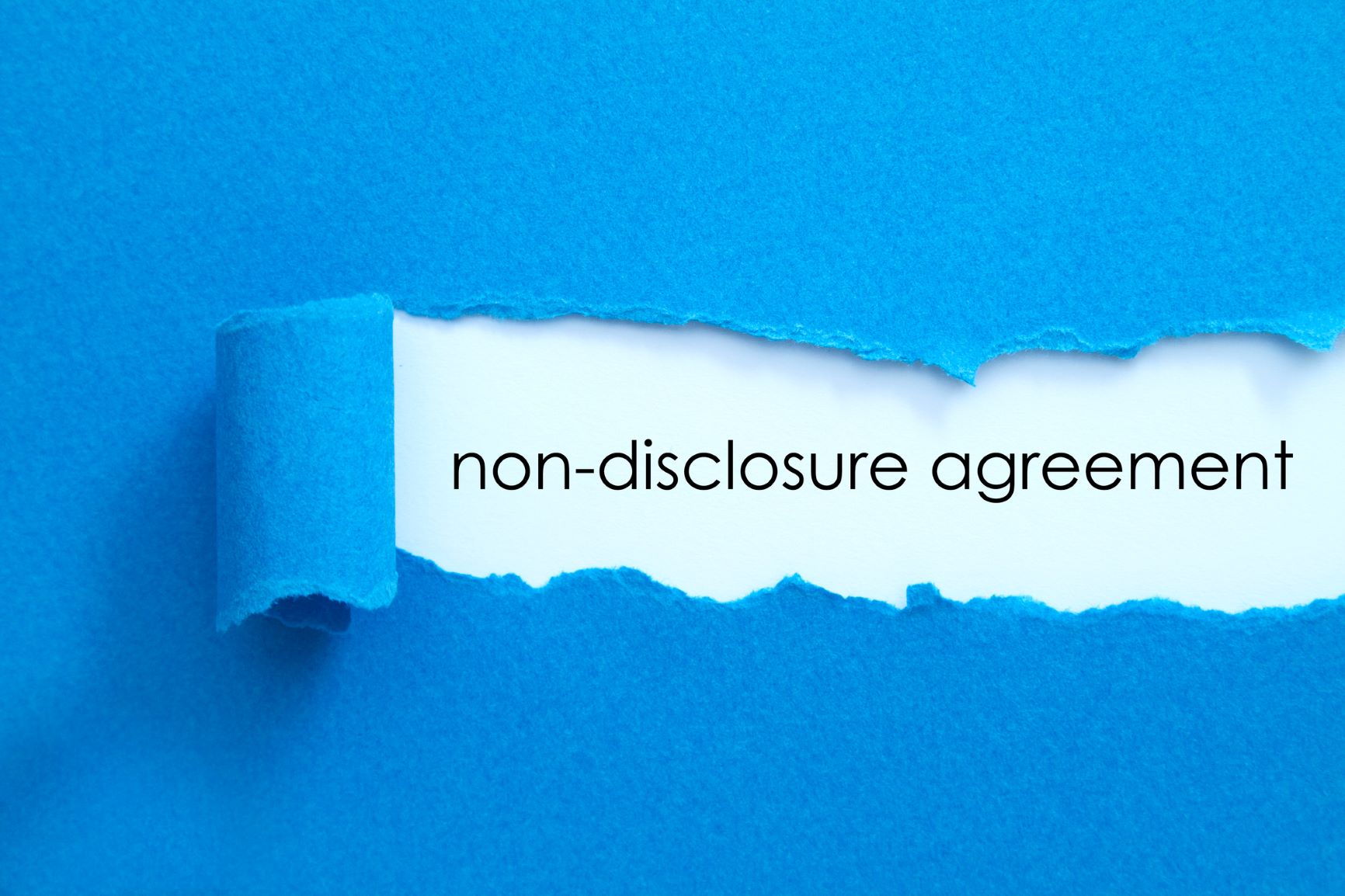 Paper torn to reveal the words 'non-disclosure agreement'