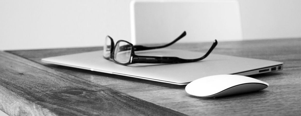 Closed laptop with glasses sitting on top